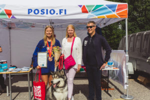 Helena, vuoden posiolainen Sini Karjalainen ja kunnanjohtaja Pekka Jääskö seisovat Posio-teltan edessä Muikkumarkkinoilla