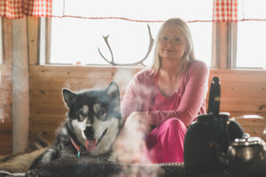 Helena ja Nome-koira kodassa istumassa